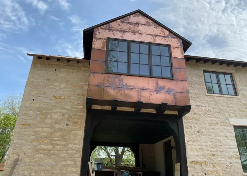 Copper metal panel facade on a stone building for Roof Repair in Raton